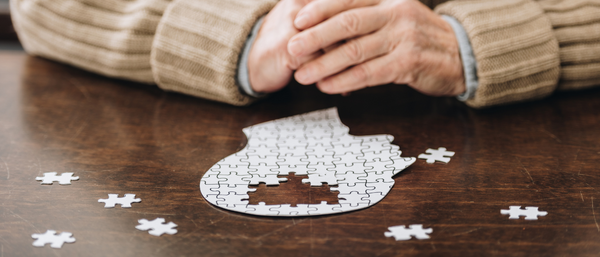 person looking at a puzzle missing pieces where the brain is